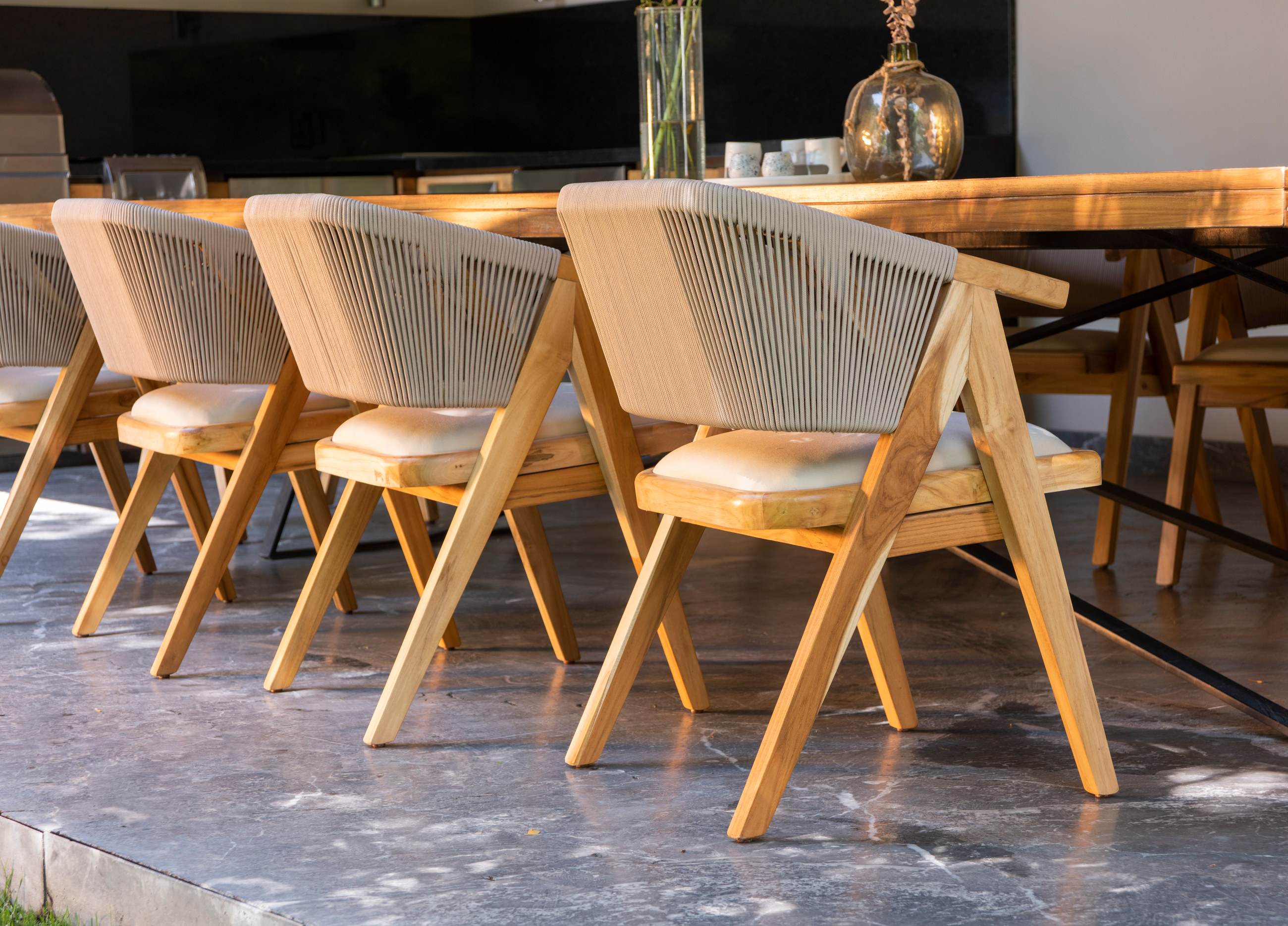 Fila de sillas de madera con respaldo de cuerda alrededor de una mesa
